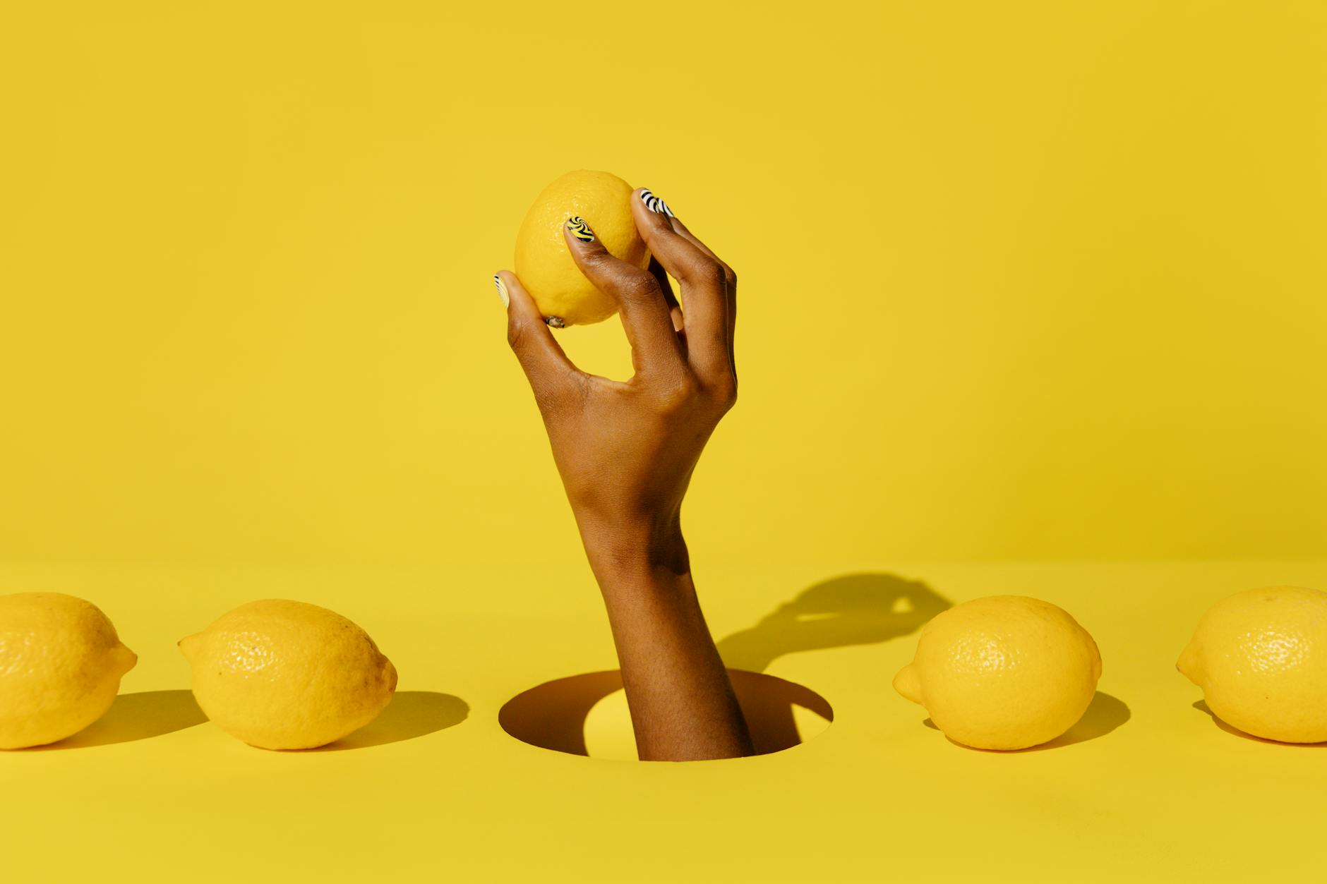 Vibrant yellow lemon vibrator surrounded by fresh lemons on a bright yellow background, symbolizing renewed desire and freshness