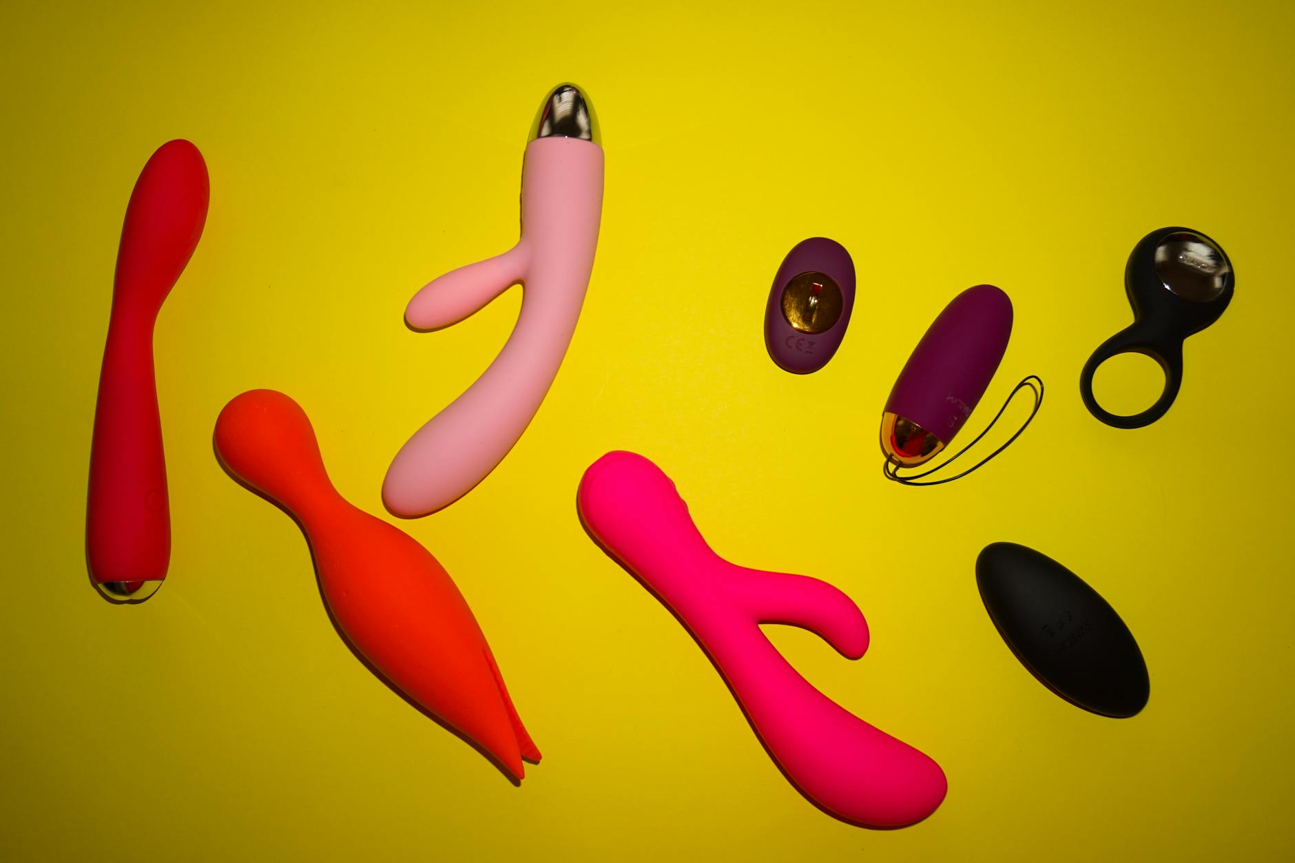 A hand holding a blue silicone clitoral vibrator against a purple background, symbolizing gentle pleasure and self-care