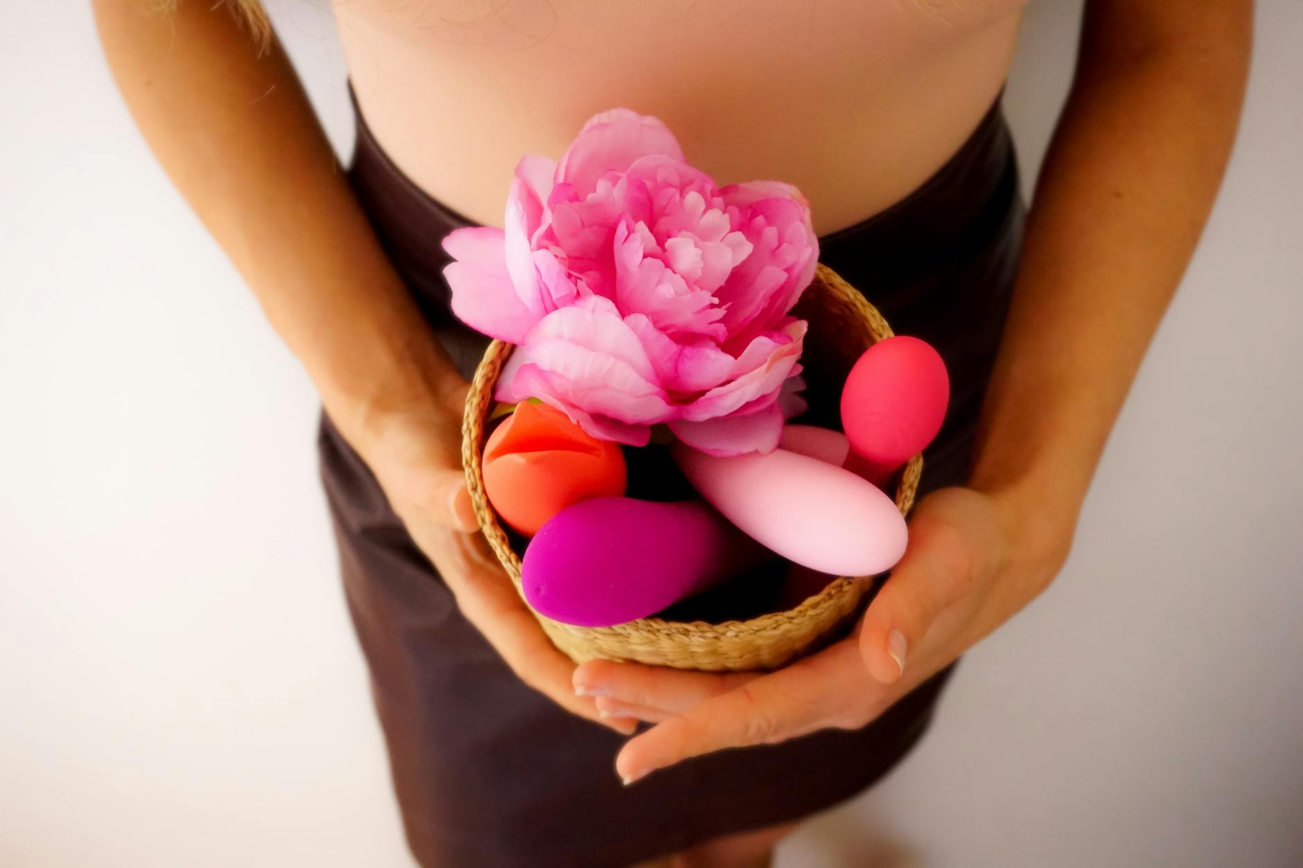 Studio setup of colorful vibrators and lemon sexual toys on a bright yellow background