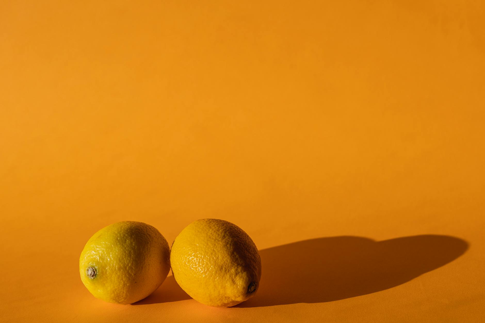 Bright yellow lemons arranged on a yellow background, symbolizing the vibrant energy of pleasure-focused design